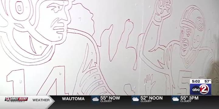 Muralist creates paint-by-numbers Packers fence