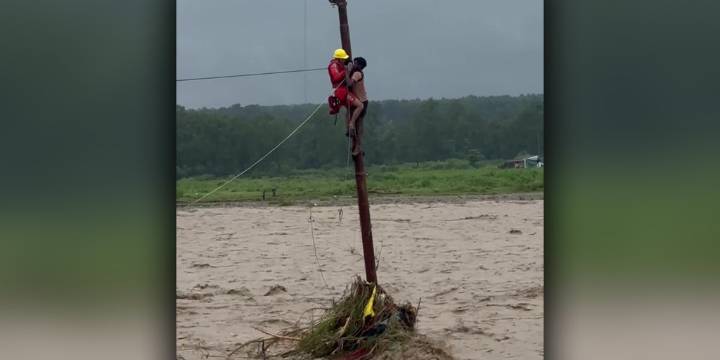 Man rescued after spending hours clinging to utility pole during India's deadly flooding