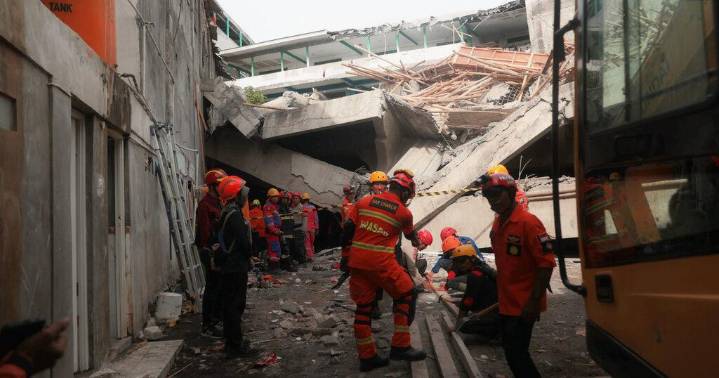 Rescuers run oxygen to survivors in Indonesia school building collapse that buried dozens