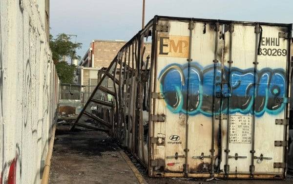 Incendian contenedores en centro comercial; detienen a uno