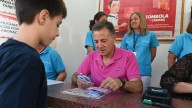 Manuel Serrano apoya a la Tómbola de Cáritas en la Feria de Albacete y se pone a vender boletos como un voluntario más