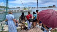 Mujeres, niñas y niños despiden a pescadores desde La Puntilla, en Mazatlán
