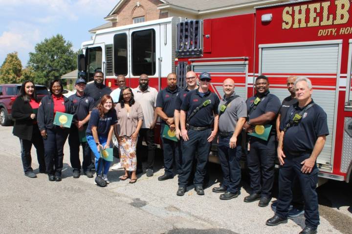Emergency responders celebrate with patient after full recovery