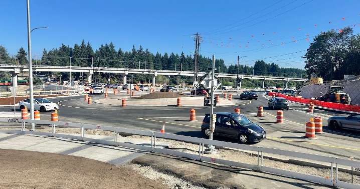 Cars and pedestrians navigate the new roundabout on 145th