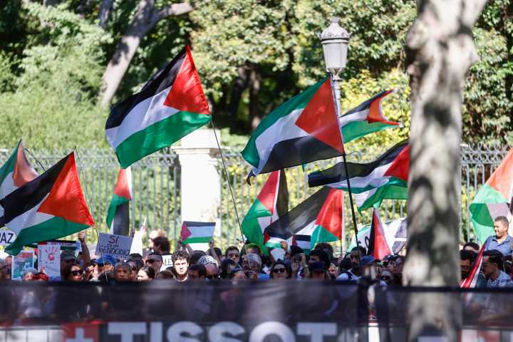 Las banderas palestinas se agitan antes de la llegada de la Vuelta en el centro de Madrid