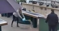 Woman pees in bucket at garden centre in front of stunned shoppers