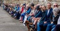 238 people squeeze onto world’s longest railway bench