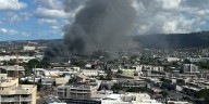 Smoke fills the air as firefighters battle building fire