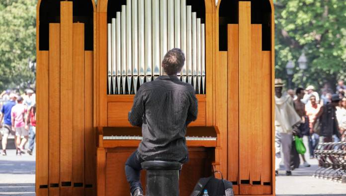 Unemployed Church Organist Playing On Street Corner For Tips