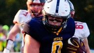 Regina football player Tate Wallace catches a pregame pass in Week 2