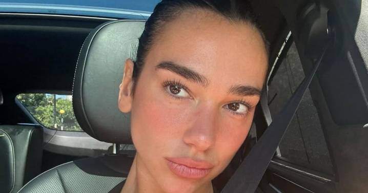 Dua Lipa Poses in White Backless Dress & Fans Can't Get Enough
