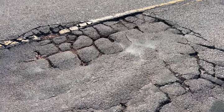 Potholes, cracks, blind spots on road near I-26 leave neighbors frustrated