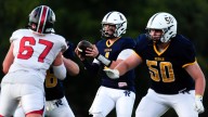 QB Kyle Tracy warms up before Regina's Week 2 game against West Branch