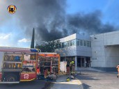Los bomberos trabajan en la extinción de un incendio industrial en una nave de Albuixech