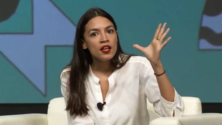 Sacrilege: Ocasio-Cortez Seen Signing Economic Textbooks