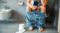 La enfermedad que acecha a quienes usan el celular sentados en el inodoro
