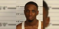 Man charged with murder after body found in woods behind IHOP