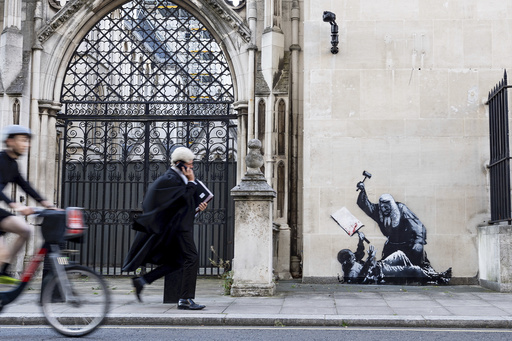 Banksy unveils a new mural of a judge beating a protester outside London court