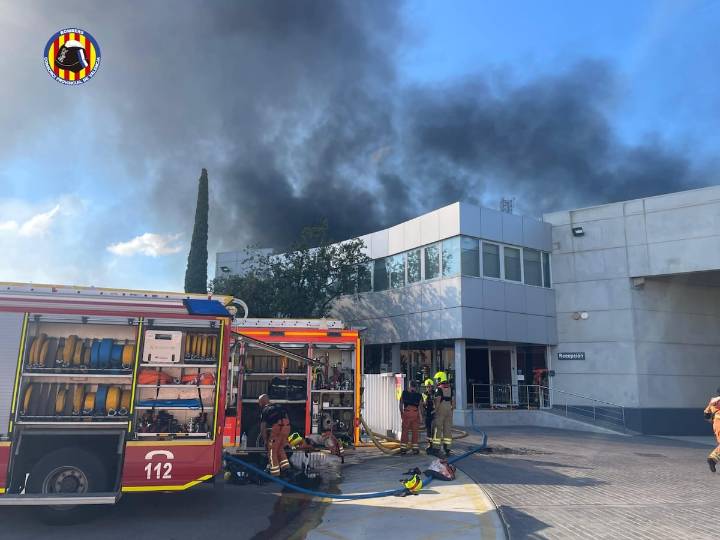 Los bomberos trabajan en la extinción de un incendio industrial en una nave de Albuixech