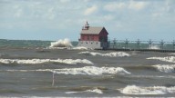 Surfers and campers ride out high waves and drifting sands in Grand Haven