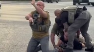 Video shows officer drop gun then appear to point it during apparent ICE arrest