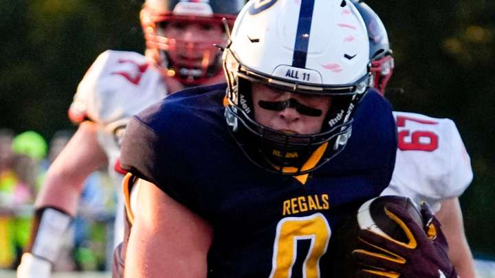 Regina football player Tate Wallace catches a pregame pass in Week 2