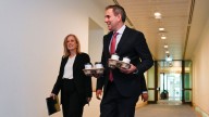 Treasurer Jim Chalmers delivers smaller-than-expected budget deficit, but opposition says he can't take credit