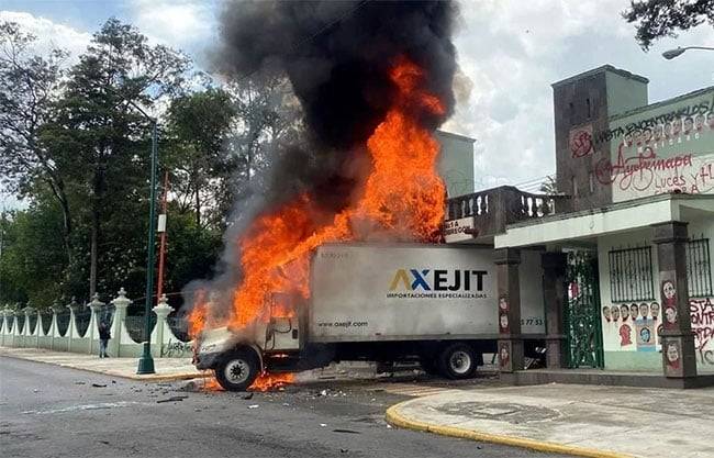 Normalistas derriban puerta del Campo militar 1-A en la CDMX y prenden fuego a un camión