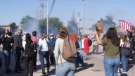Federal agents fire chemicals as protesters try to block car at immigration site outside Chicago