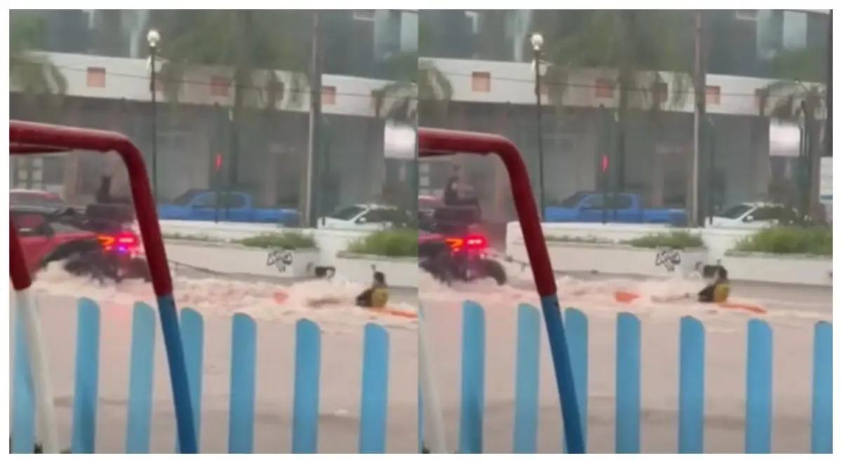 Joven navega en kayak por calle inundada tras fuerte tormenta en Puerto Vallarta