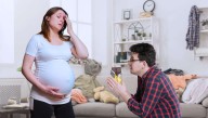 Trembling, Reverent Man Carefully Approaches Pregnant Wife And Offers Humble Sacrifice Of Chocolate