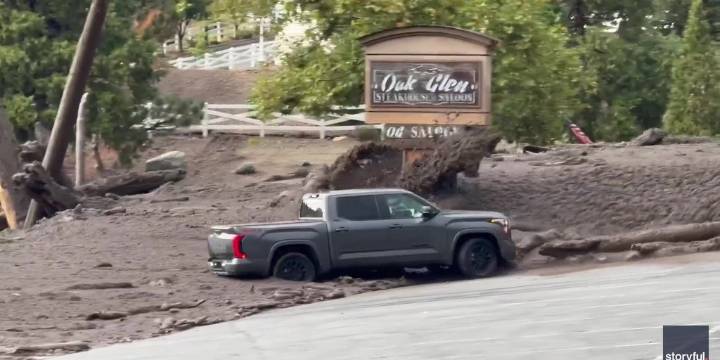 Watch: Woman trapped trying to save truck as wall of muddy water slams into California town