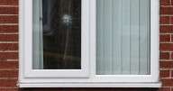 Gunman opens fire on home of 'couple and young son' with bullet hole in window