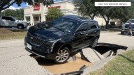Cadillac SUV tips into sinkhole near CVS Pharmacy in Harris County, Texas