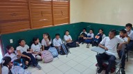 Alumnos de una telesecundaria estudian en el suelo por falta de sillas