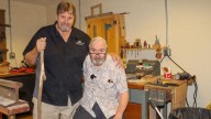 Maintenance manager and senior living resident bond over wood carving at 'Friends Village'