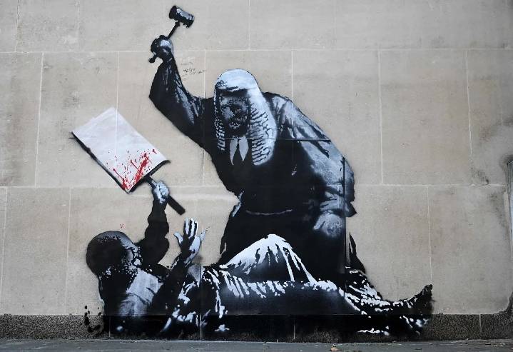 Banksy reaparece con un mural de un juez golpeando a un manifestante y las autoridades lo tapan