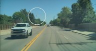 Video shows pickup truck passenger in Colorado throwing object at moving car, shattering windshield with a "boom"
