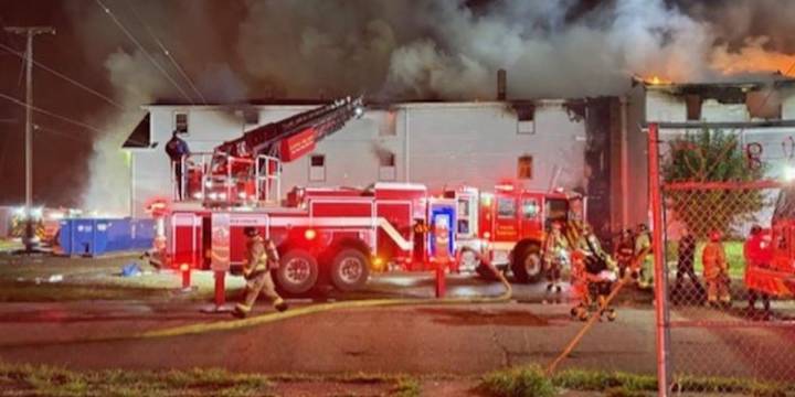Canton firefighters searching for victims after boarded up apartment building goes up in flames