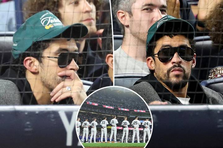 Bad Bunny sits during God Bless America at Yankee Stadium during MLB Playoff game