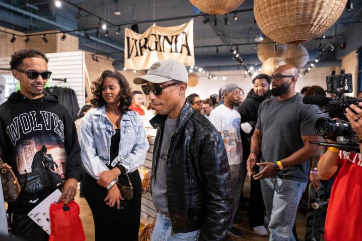 Pharrell mingles with fans, even signs a guitar
