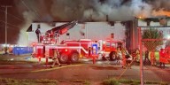 Canton firefighters searching for victims after boarded up apartment building goes up in flames