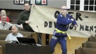 Cranford candidate Will Thilly kung fu kicks through protest signs