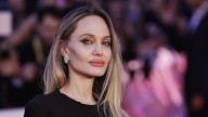 Angelina Jolie showcases her tattoos in plunging black gown