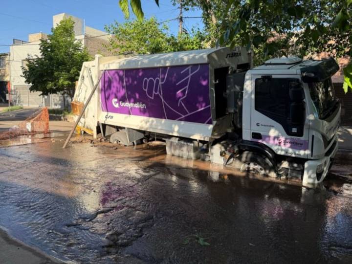 Asfalto roto. Un camión recolector quedó atrapado en un pozo durante horas por una pérdida de agua
