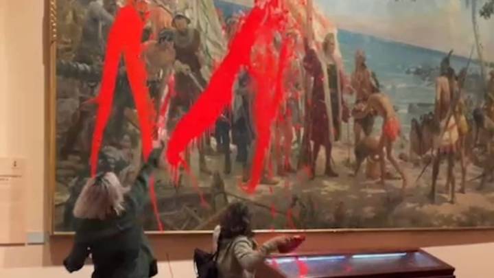 Activistas arrojan pintura contra un cuadro del Museo Naval durante el desfile del 12 de octubre