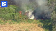 South-east Queensland suffers through extreme heat, fires and smoke a day after storm hits