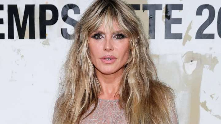 Heidi Klum reveals her bare chest in a completely see-through white dress and debuts jarring new grillz in Paris
