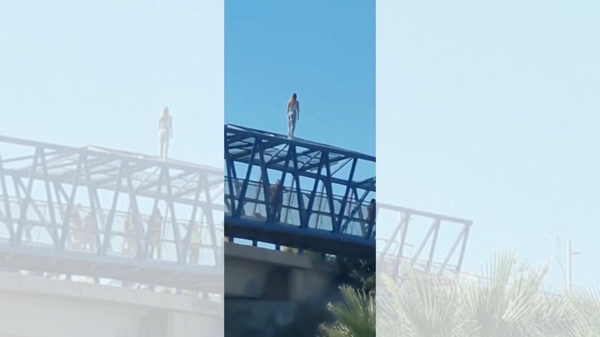 Una joven se sube a lo alto del puente sobre la AP