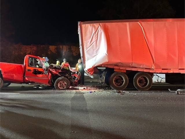 Driver extricated from pickup smashed under tractor
